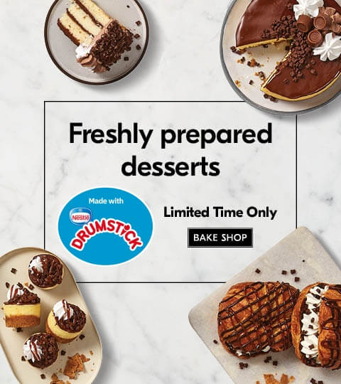 freshly__prepared__desserts__ Selection of NESTLÃâ° DRUMSTICK infused desserts ranging from a cake, cake slices and croissants on white plates, sitting on a neutral, marbled background.