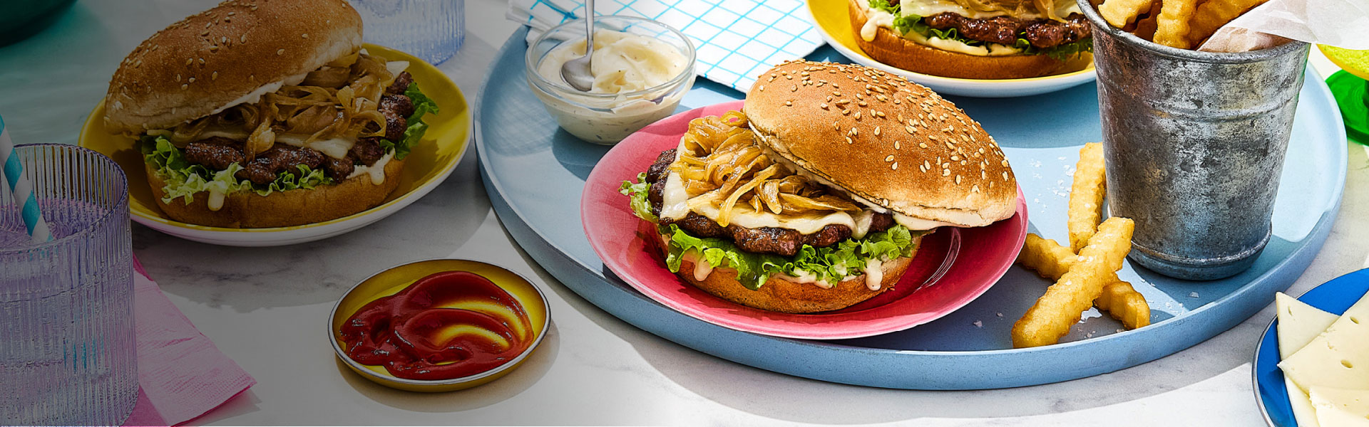 Three French onion smashed burgers with ketchup, mayo and crinkle fries on the side.