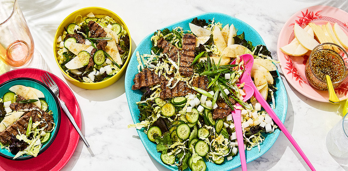 Three portions of bulgogi smashed burger salad on a marbled surface.