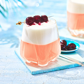 Two cherry sours in glasses garnished with 3 cherries.