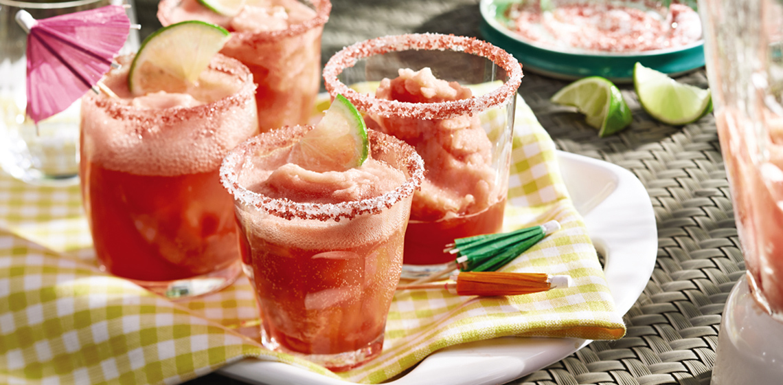 Four glasses of frozen watermelon margarita on a white serving plate.