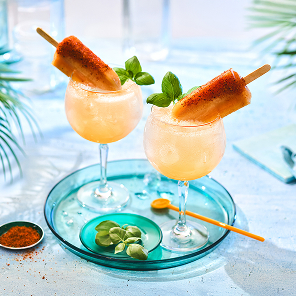 Two guava popsicle fizz cocktails on marble tabletop