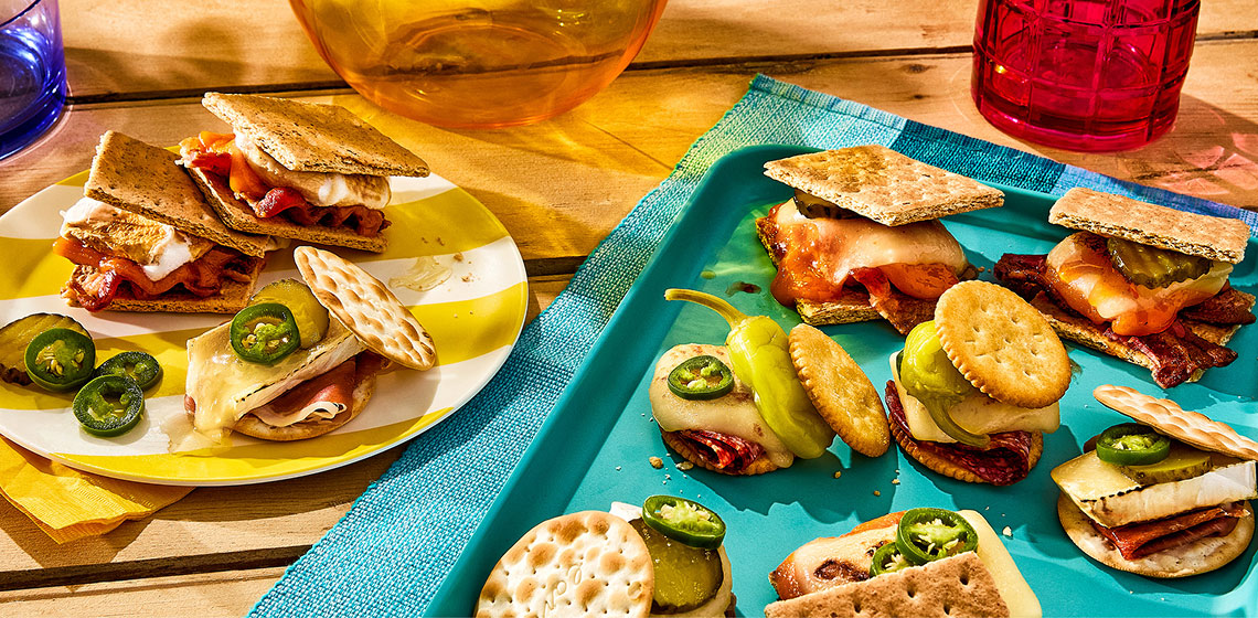 Collection of savoury smores on plates - charcuterie smores, pickle and melty brie, and double cheese and bacon.