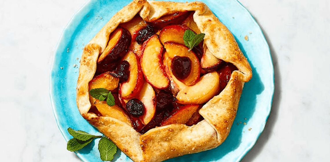 Overhead shot of stone fruit galette on a grey plate