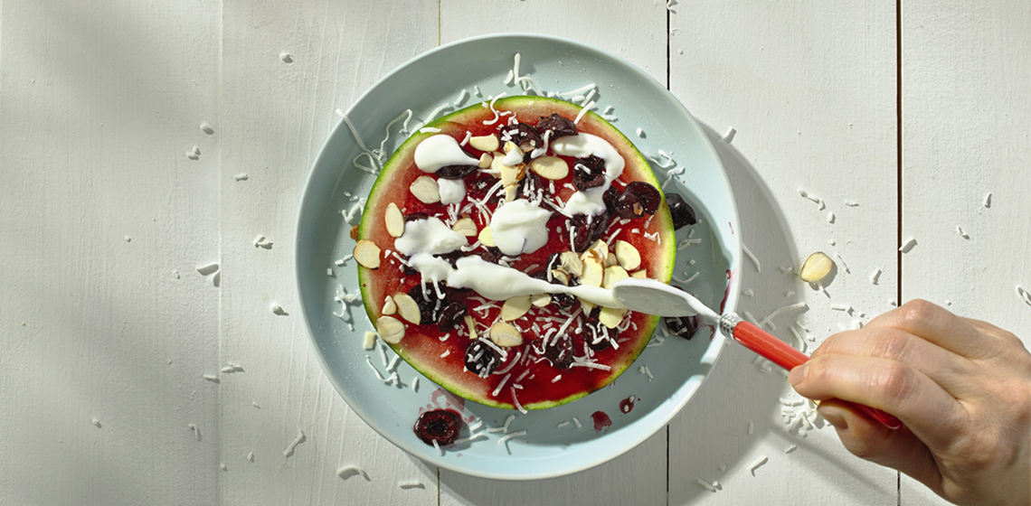 Overhead shot of sweet watermelon pizza on a blue plate.