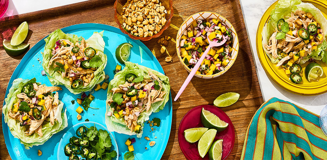 3 Thai mango chicken lettuce wraps on a plate with mango salsa in a bowl to the side. 