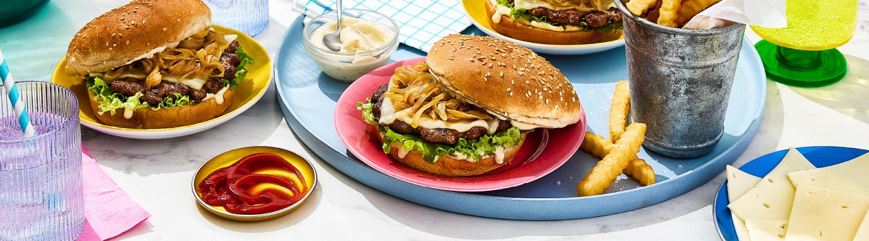 Three French onion smashed burgers with ketchup, mayo and crinkle fries on the side.
