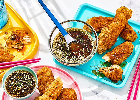 Korean chicken strips on turquoise plate with dip to the side.
