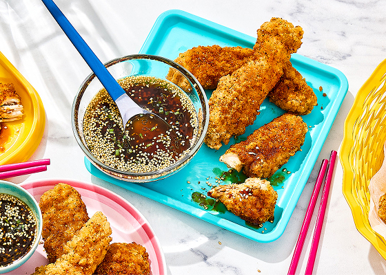 Korean chicken strips on turquoise plate with dip to the side.