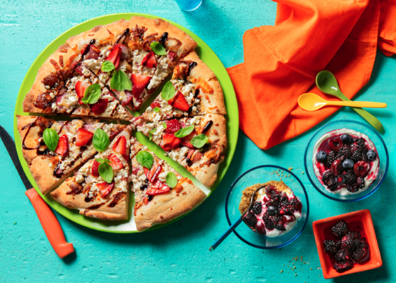 Overhead shot of fresh fruit on pizza and scoops of ice cream topped with fresh peaches